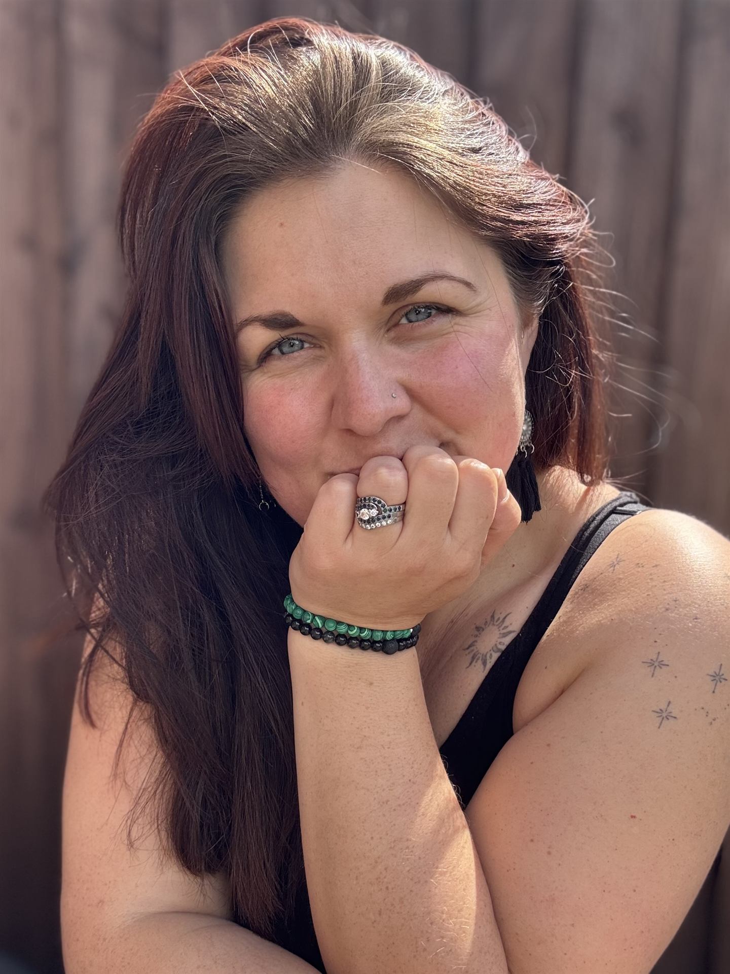 Hannah Monksummers, hand resting under her chin, smiling gently outdoors