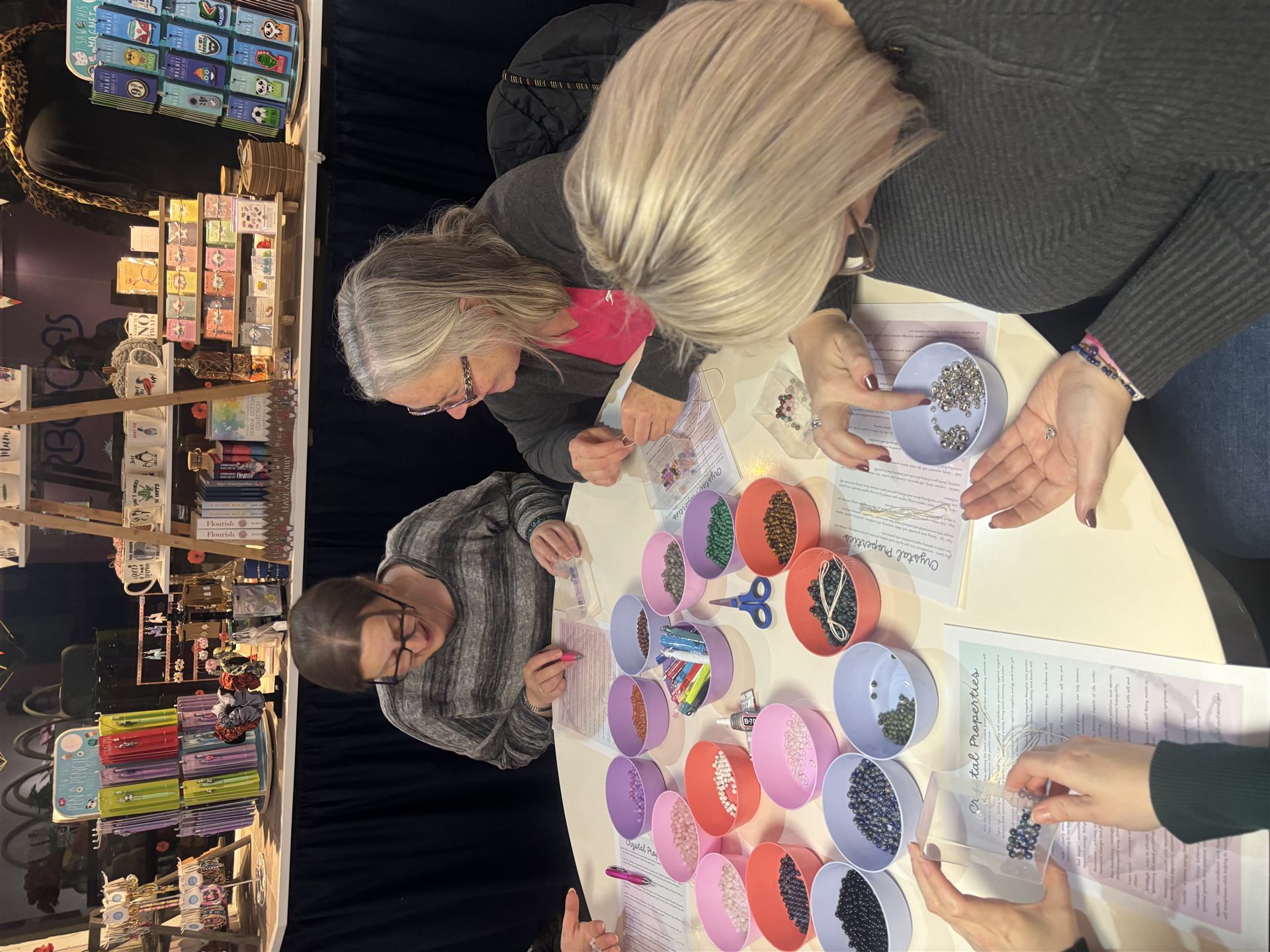 A group gathered around a table full of colourful crystal bead bowls